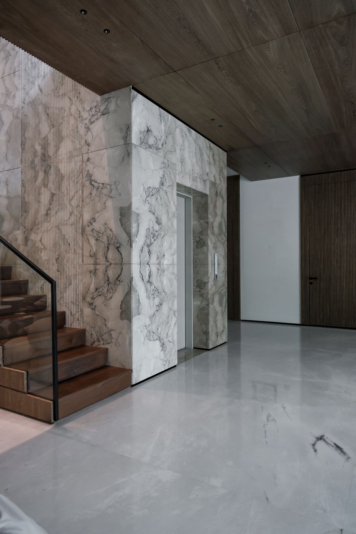 Salon de penthouse aux matières sombres, pierre et bois